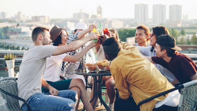 group of friends toasting drinks at a table